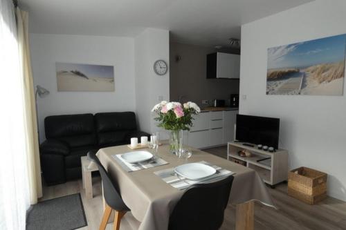 a living room with a table and a couch at Les Dunes Blanches in Le Crotoy