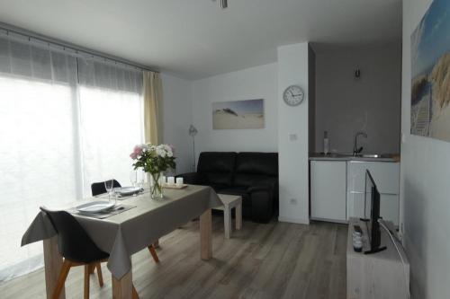 a living room with a table and a couch at Les Dunes Blanches in Le Crotoy