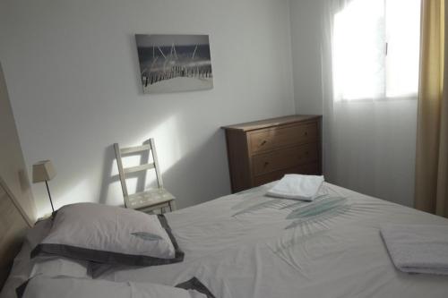 a bedroom with a bed and a dresser and a chair at Les Dunes Blanches in Le Crotoy