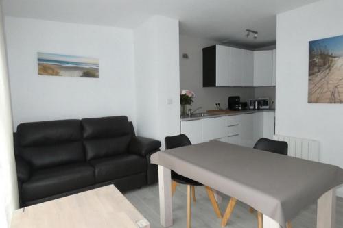 un salon avec une table et un canapé dans l'établissement Le Bois flotté, au Crotoy