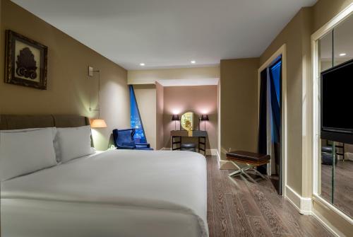 a bedroom with a large white bed and a desk at Windsor Hotel & Convention Center Istanbul in Istanbul