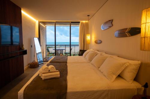 - une chambre avec un grand lit et une vue sur l'océan dans l'établissement Nanii Hotel, à São Miguel do Gostoso