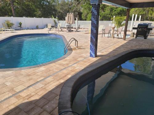 a swimming pool next to a patio with a table and chairs at Desoto Grand Estate Private Luxury Event Retreat in Sarasota