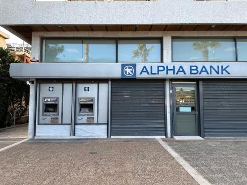 a bank building with two atm machines in front of it at Athens Sea Front Apartment, Varkiza in Varkiza