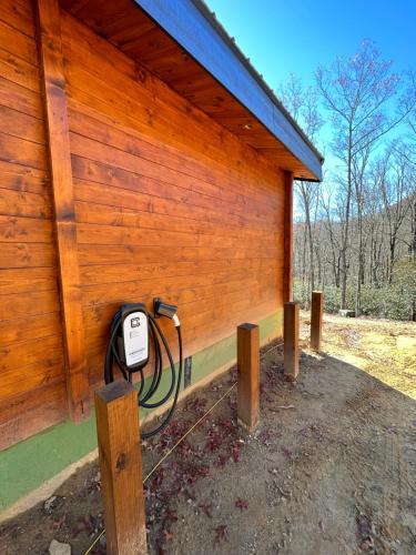 a wooden building with a phone on the side of it at Meraki Escape in Brevard