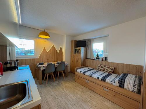 a bedroom with a bed and a kitchen with a table at Appartamento Biancaneve in Passo del Tonale