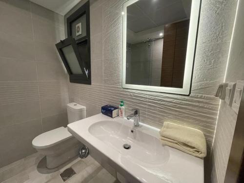 a bathroom with a sink and a toilet and a mirror at Access - luxurious apartment at cfc in Cairo