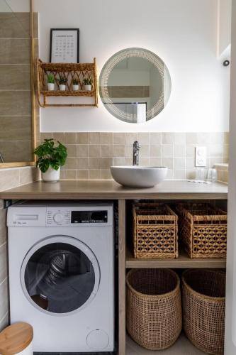une machine à laver dans une salle de bain avec un lavabo dans l'établissement Le Jadart Hyper Centre de Reims, à Reims