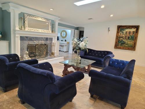 a living room with blue chairs and a fireplace at Desoto Grand Estate Private Luxury Event Retreat in Sarasota