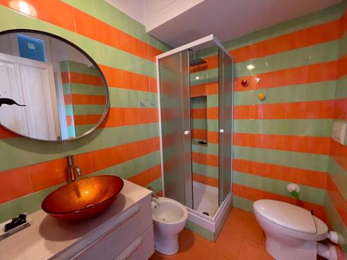 uma casa de banho com um lavatório, um WC e um espelho. em Genova la libertà dell'attico em Gênova
