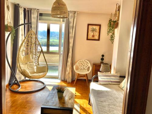 a living room with a swing in front of a window at Apartamento con vistas espectaculares al rio Sella in Ribadesella