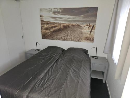 - une chambre dotée d'un lit avec une photo sur le mur dans l'établissement Chalet Veluwemeerzicht Elburg, à Biddinghuizen