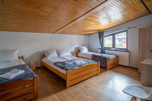 Cette chambre comprend 2 lits et une fenêtre. dans l'établissement VacationClub - Ski Lodge Szczyrk Pokój 4, à Szczyrk