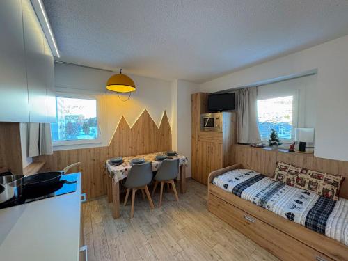 a bedroom with a bed and a table with chairs at Appartamento Biancaneve in Passo del Tonale