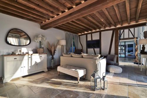 un salon avec un lit et un canapé dans l'établissement Le jardin des Hespérides - piscine intérieure Proche Pont Audemer jacuzzi 6P, à Trouville-la-Haule