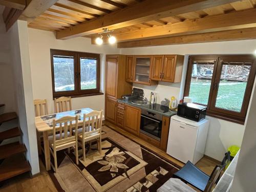 a kitchen with a table and a dining room at Chata u Jána in Zákamenné