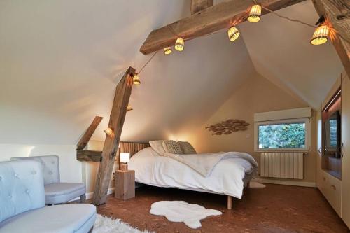 une chambre avec un lit, une chaise et une fenêtre dans l'établissement Le jardin des Hespérides - piscine intérieure Proche Pont Audemer jacuzzi 6P, à Trouville-la-Haule