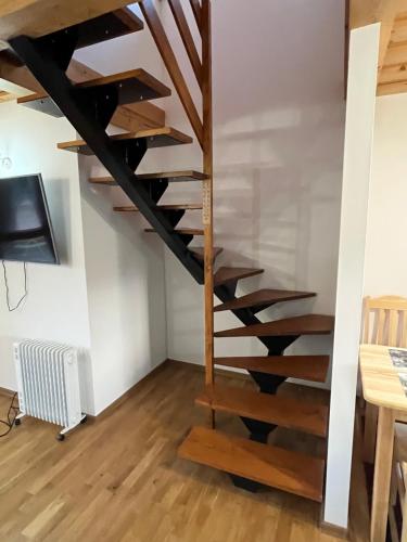 a spiral staircase in a room with a table at Chata u Jána in Zákamenné