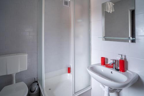 a white bathroom with a sink and a shower at VacationClub - Ski Lodge Szczyrk Pokój 5 in Szczyrk