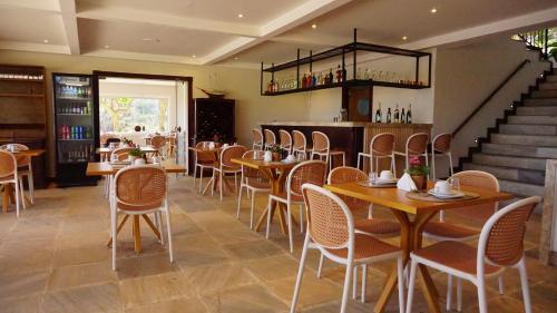 a restaurant with tables and chairs and a staircase at Uni Boutique Hotel & Spa in Búzios