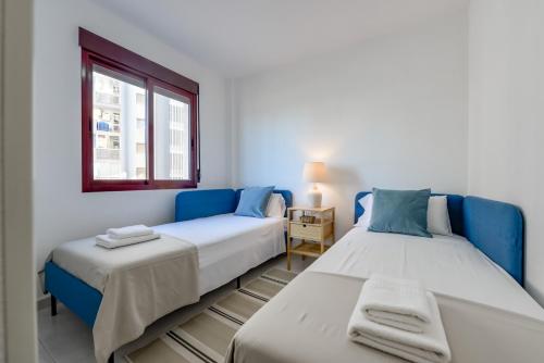 カルプにあるVillas Guzman - Apartamento Topacio IVのベッド2台と窓が備わる客室です。