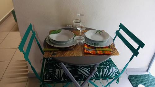 una mesa con platos y cuencos encima en Location saisonnière T1, Guadeloupe, Morne-A-L’eau 97111, en Vieux Bourg