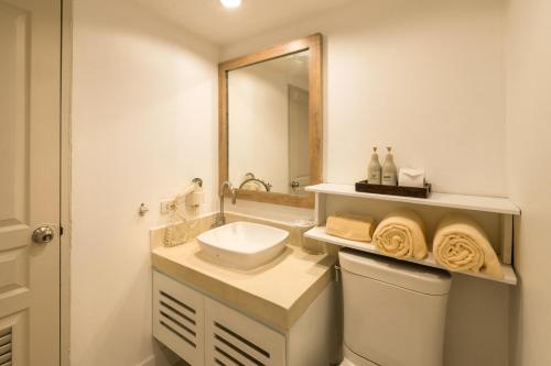 bagno con lavandino, servizi igienici e specchio di Aonang All Seasons Beach Resort ad Aonang Beach