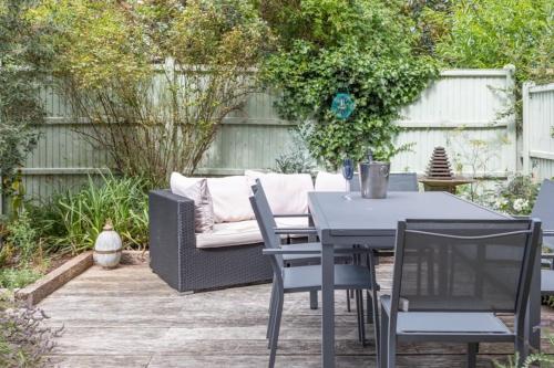 a patio with a table and chairs and a couch at Olive Tree Townhouse, with parking in Whitstable