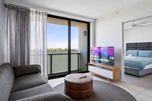 sala de estar con sofá, TV y cama en Boutique Park-view 1BR Apartment, Central location en Brisbane