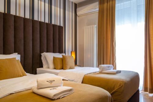 a hotel room with two beds with towels on them at Feel Belgrade Apartments in Belgrade
