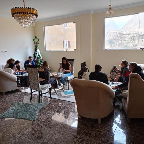 a group of people sitting in a living room at El Khalil Pyramids View Inn in Cairo