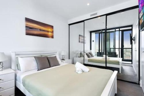 Un dormitorio blanco con una cama grande y una ventana en Stunning bridge view on a high floor FPKG en Brisbane