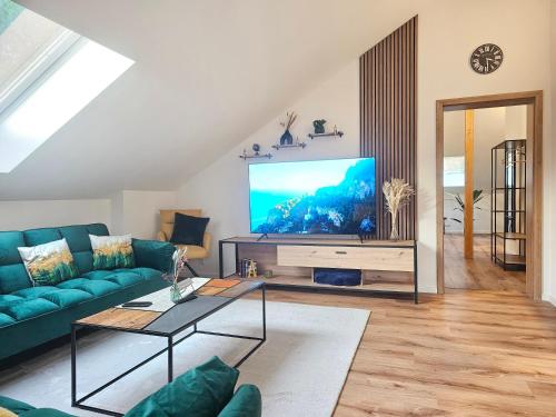 un soggiorno con divano blu e TV a schermo piatto di NEU I Penthouse 90qm I Europapark I Boxspring I Nespresso I Parking a Lahr