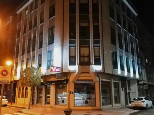 a building on the corner of a street at night at H. O Lar in O Barco de Valdeorras