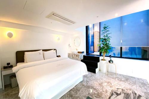 a bedroom with a white bed and a large window at Garden Pool Villa Lee Chung Jung in Seoul