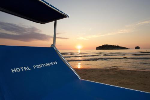a bench on the beach with the sunset in the background at Hotel Portonuovo in Vieste