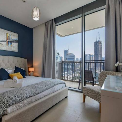 een slaapkamer met een bed en een groot raam bij Beachwalk Luxury 2BR with Infinity Pool and Views in Dubai