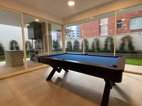a pool table in a large room with windows at Gold & Black, Premiere Suite and Pool, Sector Carolina in Quito