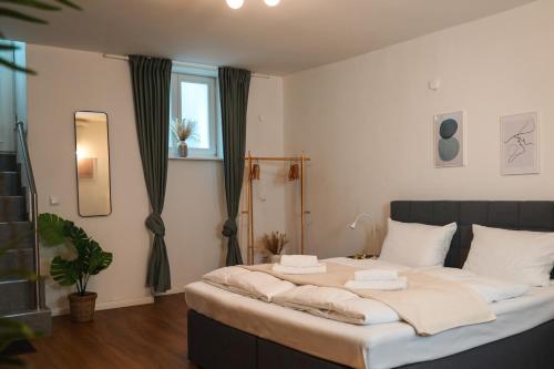 una camera da letto con un grande letto con cuscini bianchi di Global Living - Design Apartment I Central I Beamer I Kitchen I Terrace I Berlin a Berlino
