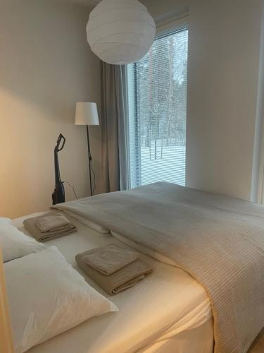a bed with towels on it in front of a window at Helsinki Airport Apartment in Vantaa