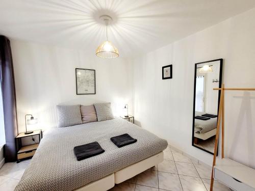 1 dormitorio blanco con 1 cama grande y espejo en Les Gîtes d'Angres - Gîte n°3, en Angres