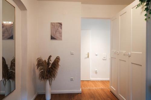 un corridoio con una porta e un vaso con una pianta di Global Living - Design Apartment I Central I Beamer I Kitchen I Terrace I Berlin a Berlino