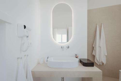 ein weißes Badezimmer mit Waschbecken und Spiegel in der Unterkunft Marhaba in Torre Pali 