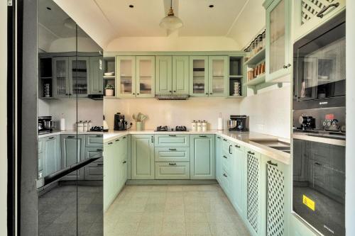 a kitchen with mint green cabinets and appliances at Casa Azul- Luxury 4bhk Assagao with private pool in Vagator