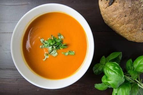 uma tigela de sopa com um pedaço de pão e manjericão em SHANTHI SAMAYA HOLIDAY HOMESTAY em Darjeeling