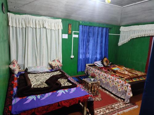 um quarto com duas camas e uma parede verde em SHANTHI SAMAYA HOLIDAY HOMESTAY em Darjeeling