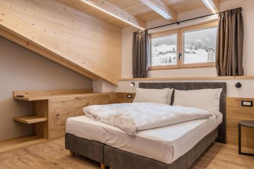 a bedroom in a tiny house with a bed at Kamerloy Apartments G in Campitello di Fassa