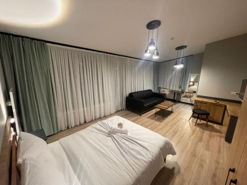 een slaapkamer met een wit bed en een woonkamer bij Taksim Millennium Alkan Residence in Istanbul