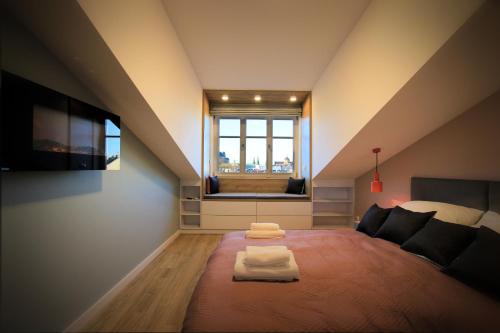 um quarto no sótão com uma cama e uma janela em Wawel View Apartment em Cracóvia