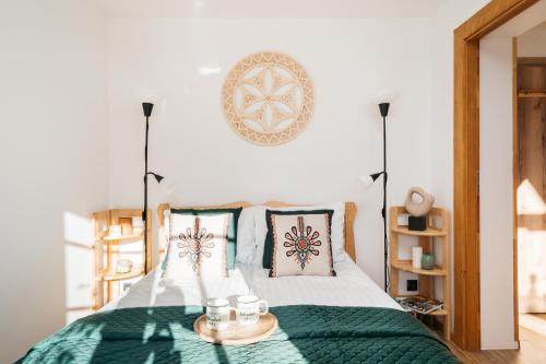 a bed with a green blanket and two cups on it at Highlander - LoftAffair in Kościelisko